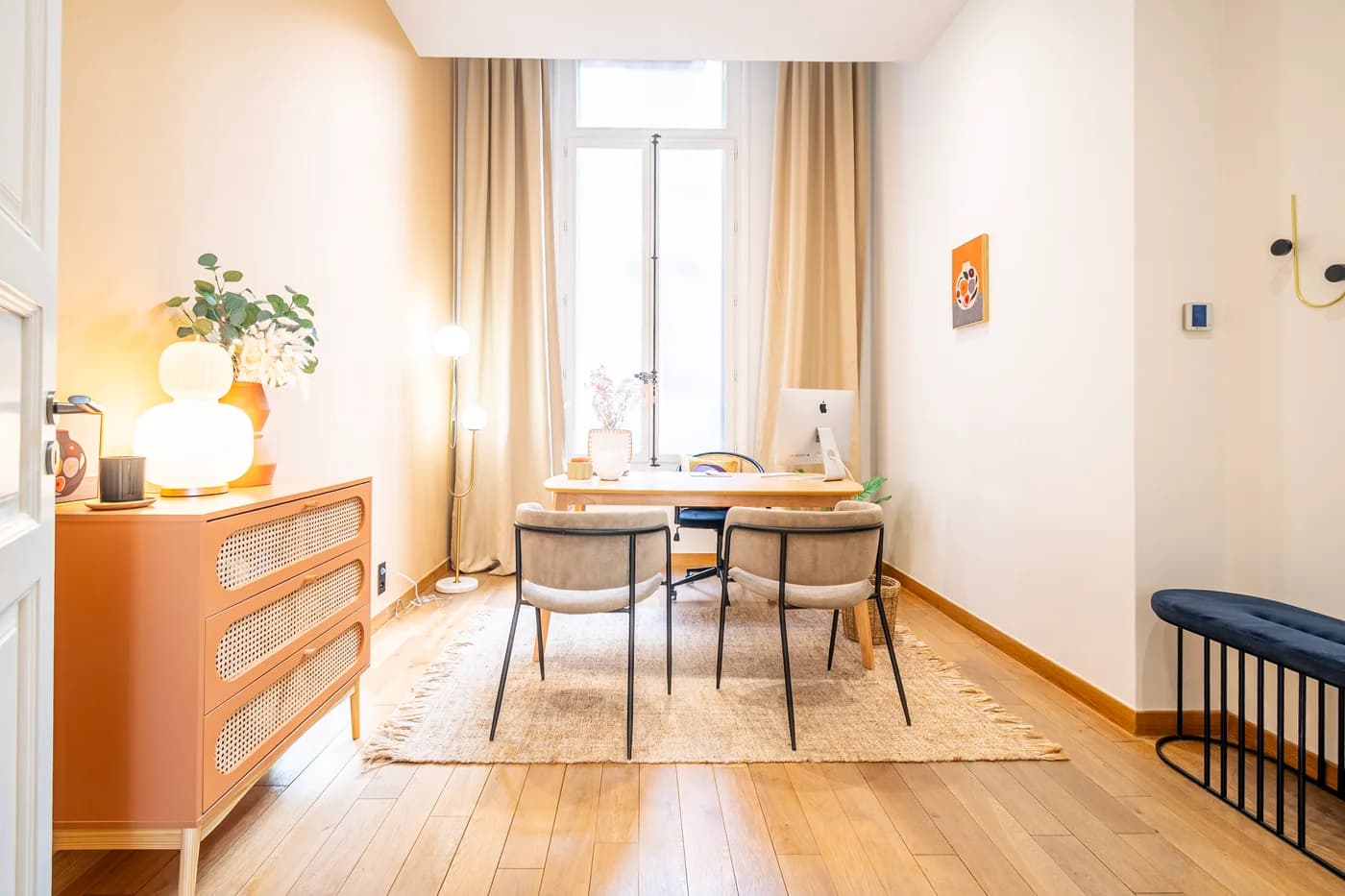 Un espace de consultation lumineux, avec deux sièges devant un bureau près de la fenêtre.